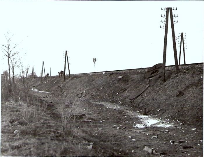  Výbuch kotla 555.3277 pri Sládkovičove 5.2.1964. Pohľad na násyp trate v km 95,3 s telegraf. tyčami. Pri koľaji ležia dýmn. dvere rušňa a malé úlomky. Anon., 2.1964. 113 x 83, 