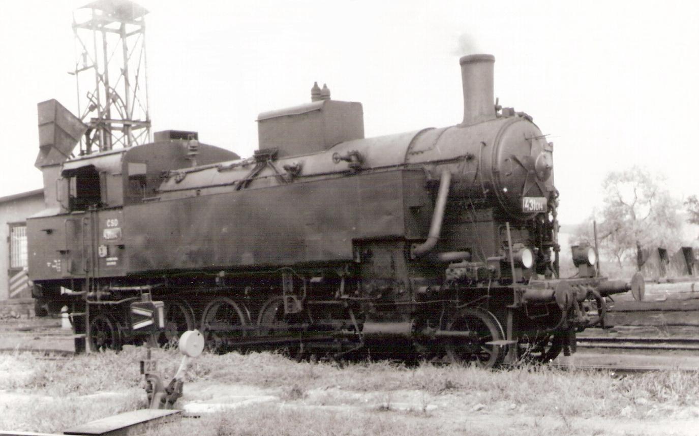  Parný rušeň 431.014, pohľad zprava zpredu. Vľavo vzadu jednokomorový Teudloff. Osvetľ. stožiar. Anon., cca 1970. 176 x 125 