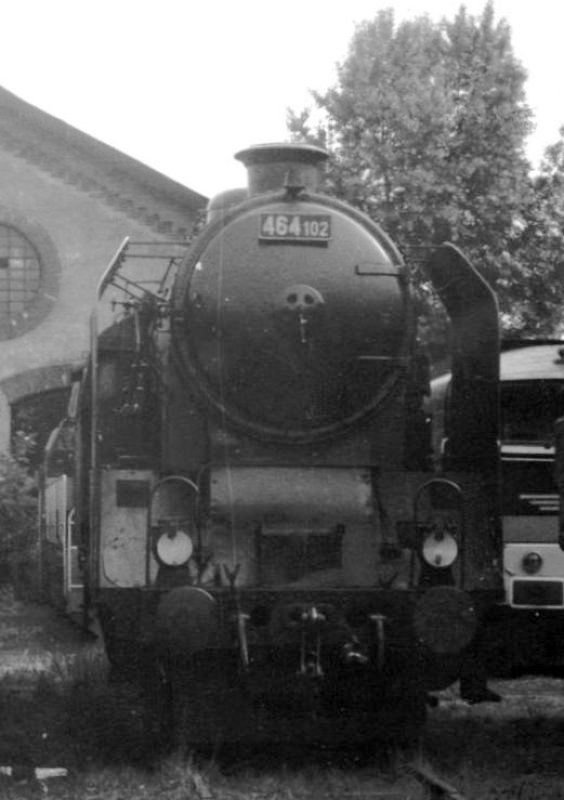  Parný rušeň 464.102 v depe Praha Bubny. Pohľad zpredu.Vľavo T 478.1, vpravo T 478.3, vzadu priečelie starej haly (StEG). Anon., 18.6.1988. 90 x 130 