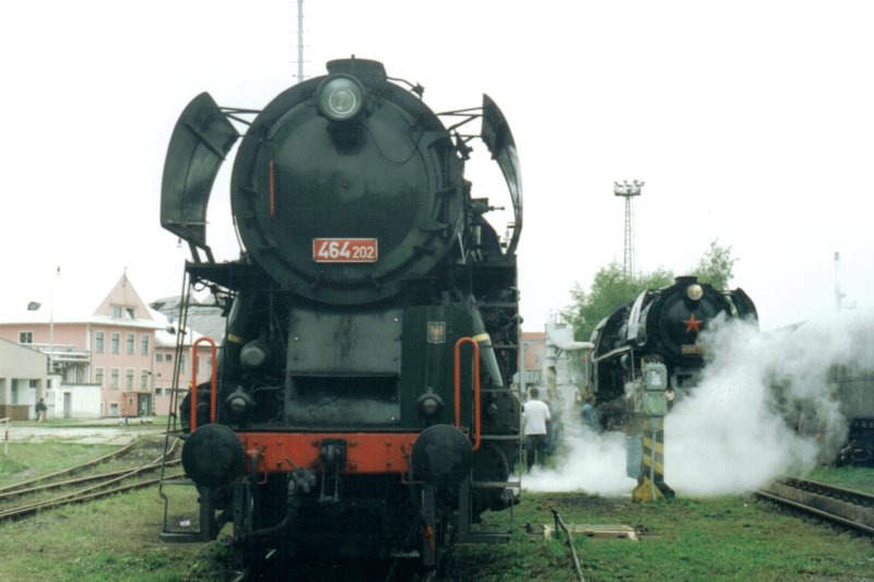  Parný rušeň 464.202 v obvode depa (Olomouc ?). Pohľad zpredu. Vpravu vzadu 498.104. Anon., cca 2000. 150 x 102, COLOR 