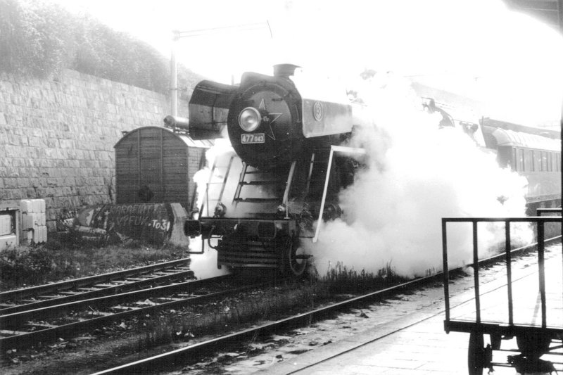  Parný rušeň 477.043 so salón. vozňom počas odchodu z 5. perónu žst. Bratislava hl. Pohľad zľava zpredu. Vpravo 4. perón s vozíkom na batožinu. Foto. J. Horník, 18.10.1980. 148 x 105 