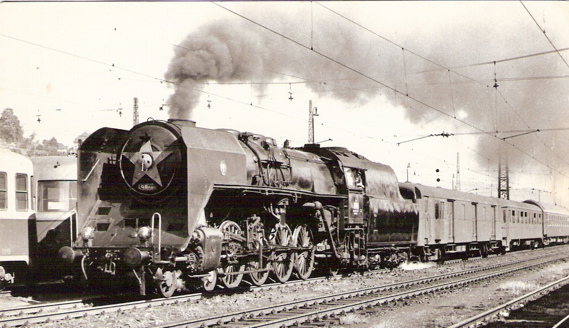  Parný rušeň 498.003 + Da + Aa + súprava Ba. Pohľad zľava zpredu. Troleje, vľavo prívesy k M 240.0. Foto: P. Vančura, cca 1970. 144 x 103. Pohľadnica Pressfoto Praha. 