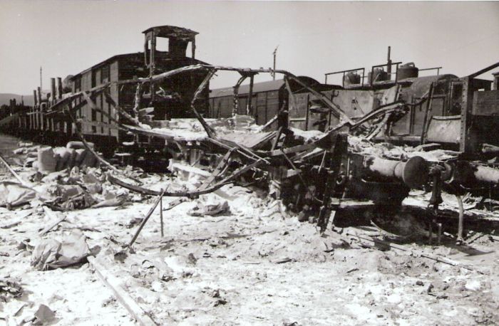  Bratislava sriaď. nádražie. Rozbité a zhorené vozne v smerovej skupine po bombardovaní. Vzadu Karpaty. Anon., 1945. 123 x 80 