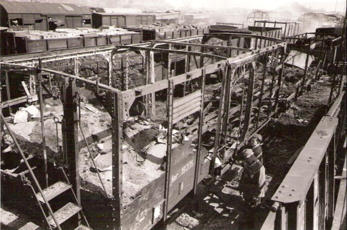 Bratislava sriaď. nádražie. Rozbité a zhorené vozne v smerovej skupine po bombardovaní. Pohľad z nadhľadu, vpravu hore vidno odchodové návestidlo na Vajnory. Anon., 1945. 123 x 81 