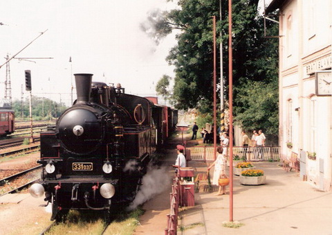  Parný rušeň 331.037 v žst. Vajnory. Pohľad zpredu, vľavu časť priečelia výpravnej budovy. Foto: M. Entner, 1998. 178 x 126, COLOR 