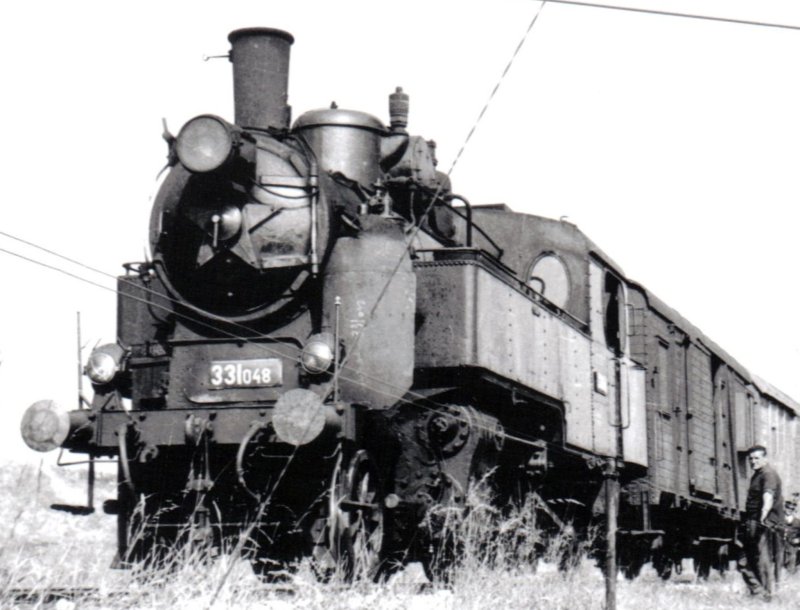  Parný rušeň 331.048 + D (povojnový, pre nákl. vlaky) + Ztr na trati Podolinec - Kežmarok. Pohľad zľava zpredu. Vpredu drôtovod. Anon., 1959. 125 x 89. Archív R. Chalupa 