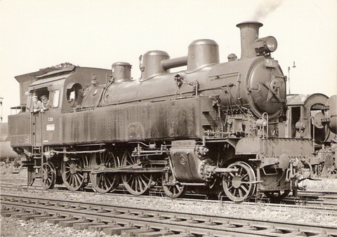  Parný rušeň 354.1207 (na kabíne nápis Depo Rakovník) v obvode neurč. depa. Pohľad zprava zpredu. Vzadu odstavená 555.3. Foto: P. Vančura, cca 1970. 143 x 104. Pohľadnica - Pressfoto Praha 