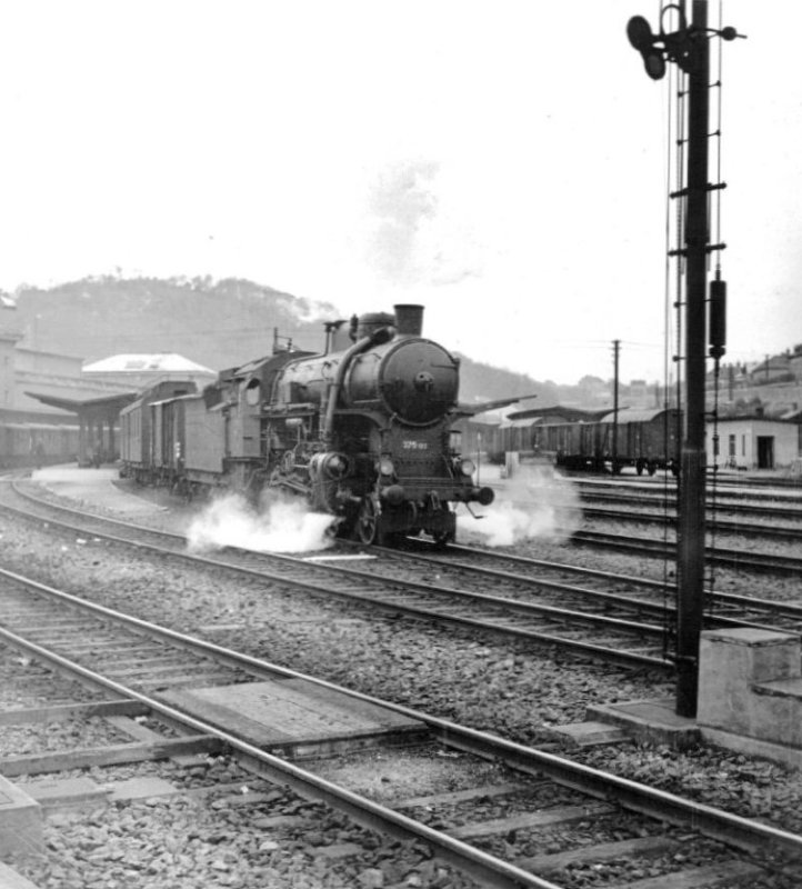  Parný rušeň 375.103 + Z + Fa odchádza z Bratislavy hl. st. na Raču. Pohľad zprava zpredu od odchod. návest. Vpredu spodok mech. odchod. návestidla. Koľajisko stanice, časť výpr. budovy, nákl. a osob. vlak. Anon., cca 1950. 177 x 182 