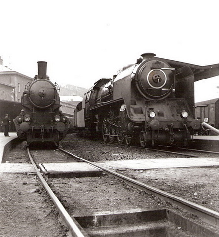 Parné rušne 387.001 (vpravo, 2. koľaj) a 344.4 (vľavo, 1. koľaj) pri 1. a 2. peróne žst. Bratislava hl. st. Pohľad zpredu od Rače. Vpredu prechod, vzadu časť výpr. budovy, peróny, vpravo vozeň Ztr. Anon., cca 1950. 177 x 205 