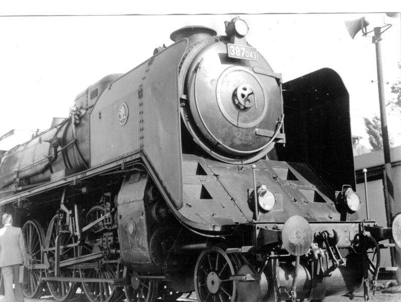  Parný rušeň 387.043 - pohľad zprava zpredu iba na prednú časť rušňa po kabínu. Vpravo stĺp s reproduktormi. Foto: M. Macura, cca 1980. 180 x 130 