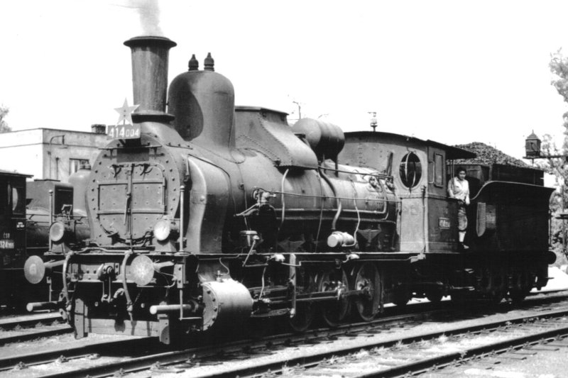  Parný rušeň 414.004. Pohľad zľava zpredu. Vzadu vľavo kúsok 324.355, vzadu vpravo zariadenie pre zbrojenie piesku. Foto: P. Vančura, cca 1965. 145 x 102. Pohľadnica Pressfoto Praha. 