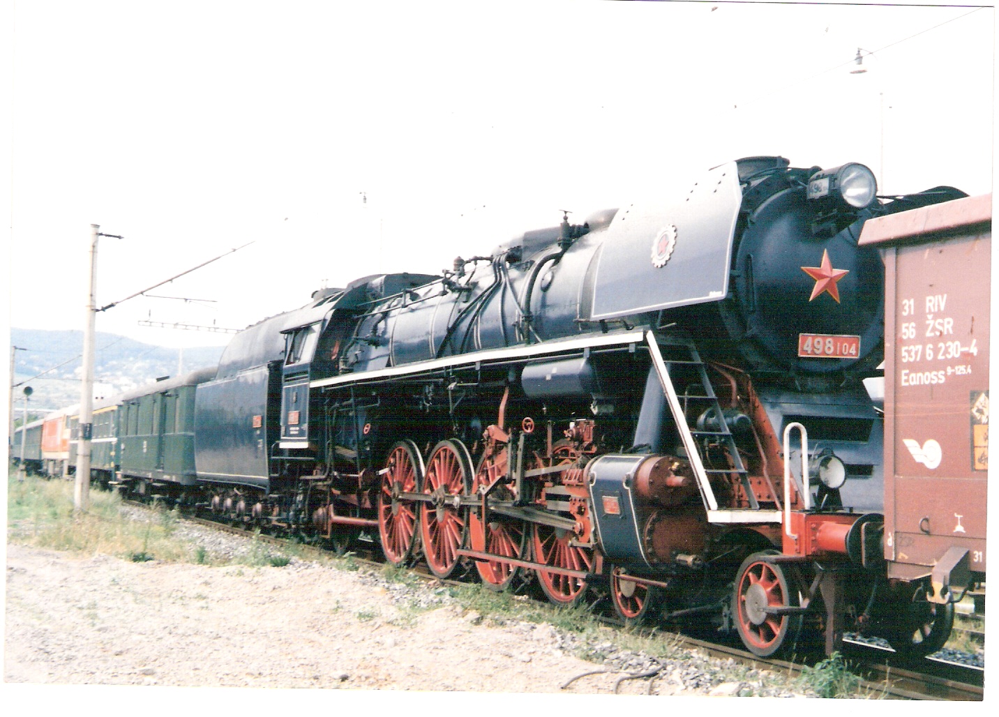  Parný rušeň 498.104 v konvoji pri vjazde do Bratisl. východ počas návozu z Vrútok do Brat. (oslavy 150. výročia žel. na Slov.). Pohľad zprava zpredu. Foto: M. Entner, august 1998. 178 x 126, COLOR 