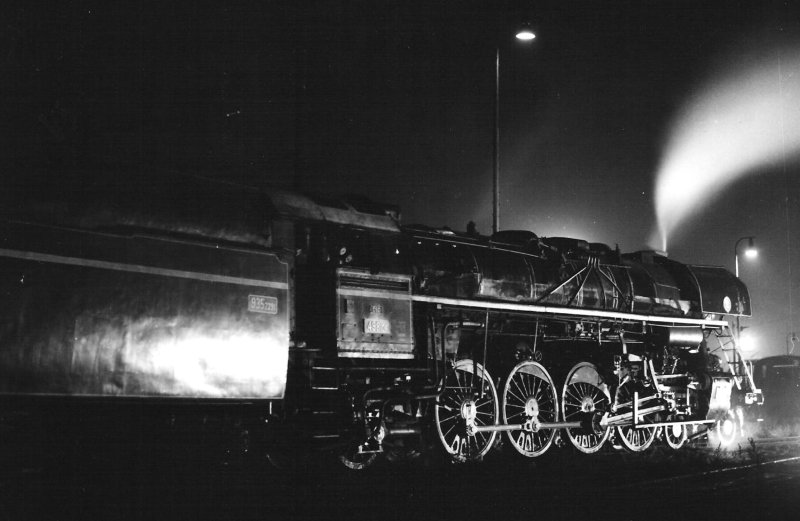  Parný rušeň 498.106. Nočný pohľad zprava zozadu. Vidno iba časť tendra. Anon., 9.1981. 180 x 130 