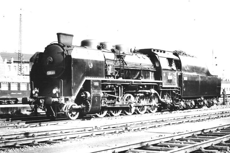  Parný rušeň 534.0459 v žst. Praha Libeň. Pohľad zľava zpredu. Trolej, vľavo vzadu časť WLAB z r. 1959. Foto: J. Bosáček, cca 1970. 177 x 126 