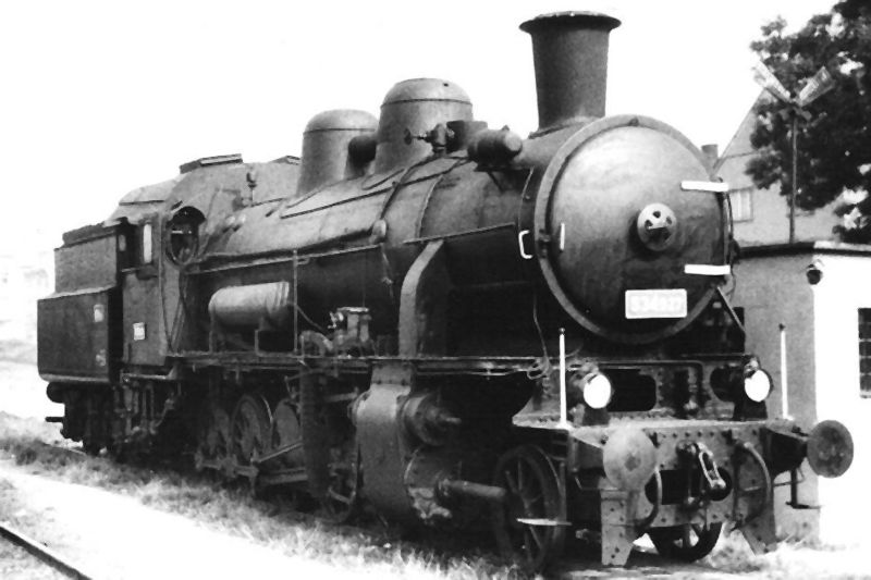  Parný rušeň 534.027 v žst. Nymburk. Pohľad zprava zpredu. Vpravo roh objektu koľaj. váhy. Anon., 17.9.1982. 122 x 84 