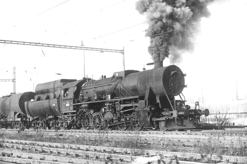  Parný rušeň 555.3 + Ra pri odchode na zhlaví žst. Bratislava Nové Mesto smer ÚNS. Pohľad zprava zpredu. Trolej, osvetľ. stožiar. Foto: L. Plevka, cca 1972. 178 x 130 