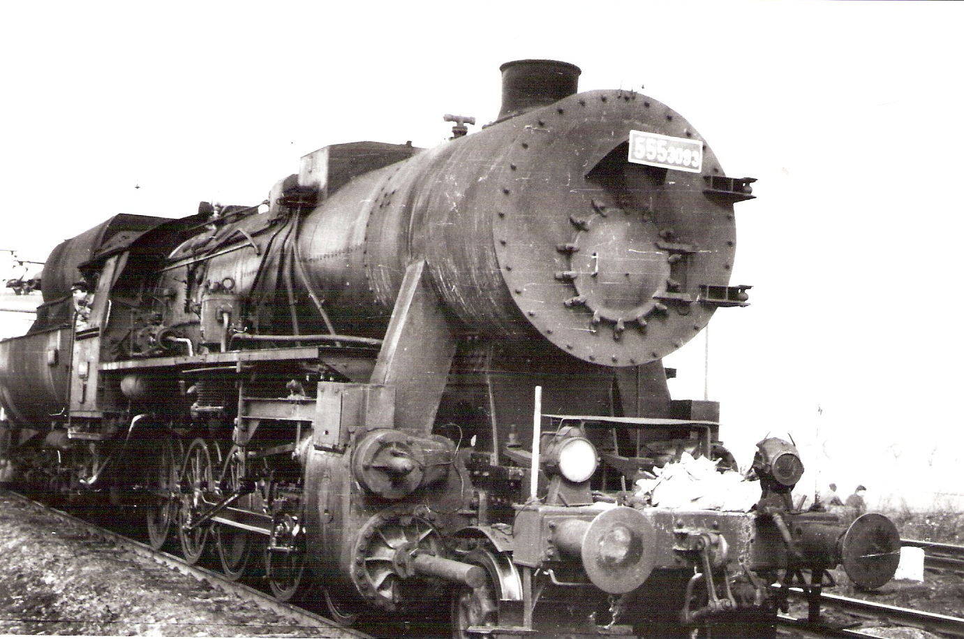  Parný rušeň 555.3093 + jednosyst. el. rušeň v Prahe Strašniciach. Pohľad zprava zpredu. Anon., 11.1970. 177 x 118 