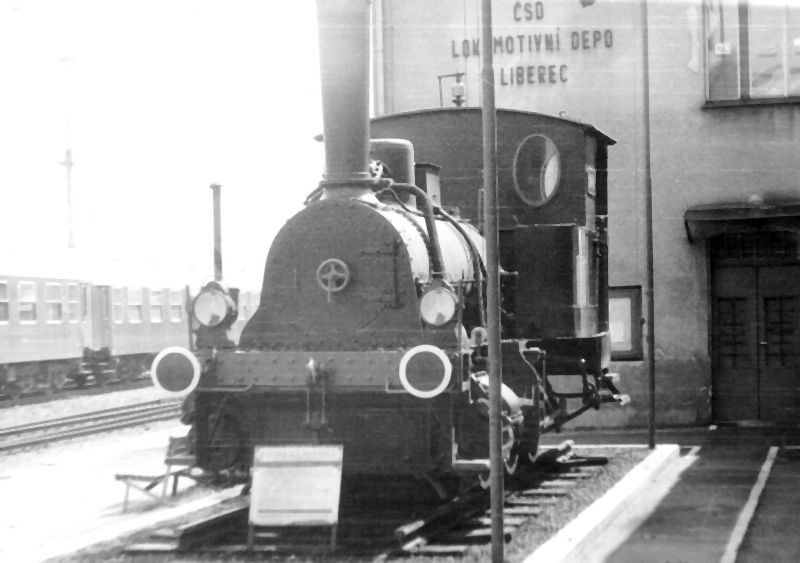  Parný rušeň trojnápr. Krauss Mníchov 1882 (Adolf) na pomníku v depe Liberec. Pohľad zľava zpredu. Foto: J. Česák, cca 1990. 148 x 104 