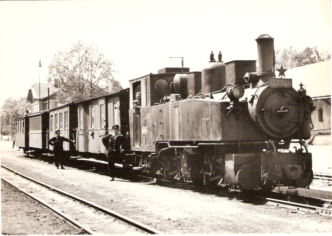  Úzkorozch. parný rušeň U 47.001 + D/u + 3 Ci/u v žst. Jindř. Hradec. Pohľad zprava zpredu. Vzadu priečelie výpravnej budovy osvetľ. stožiar. Foto: P. Vančura, cca 1960. 144 x 102 