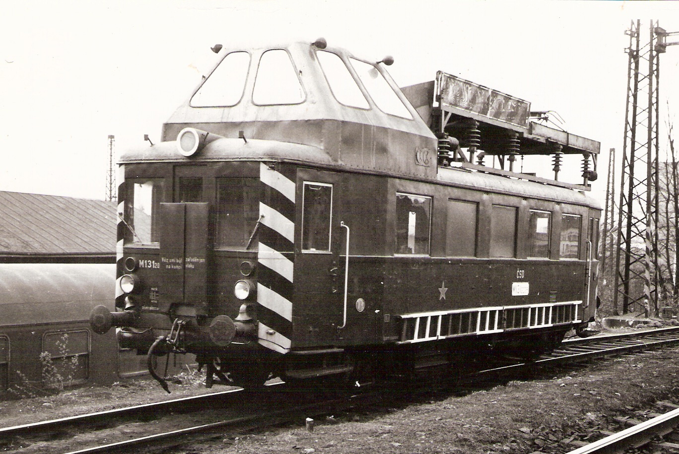  Prehliadkový motorový vozeň OTV M 131.2025. Pohľad predobočný. Vľavo dole odstavený vozeň Ba, vpravo trakč. podpera. Anon., cca 1975. 176 x 123 