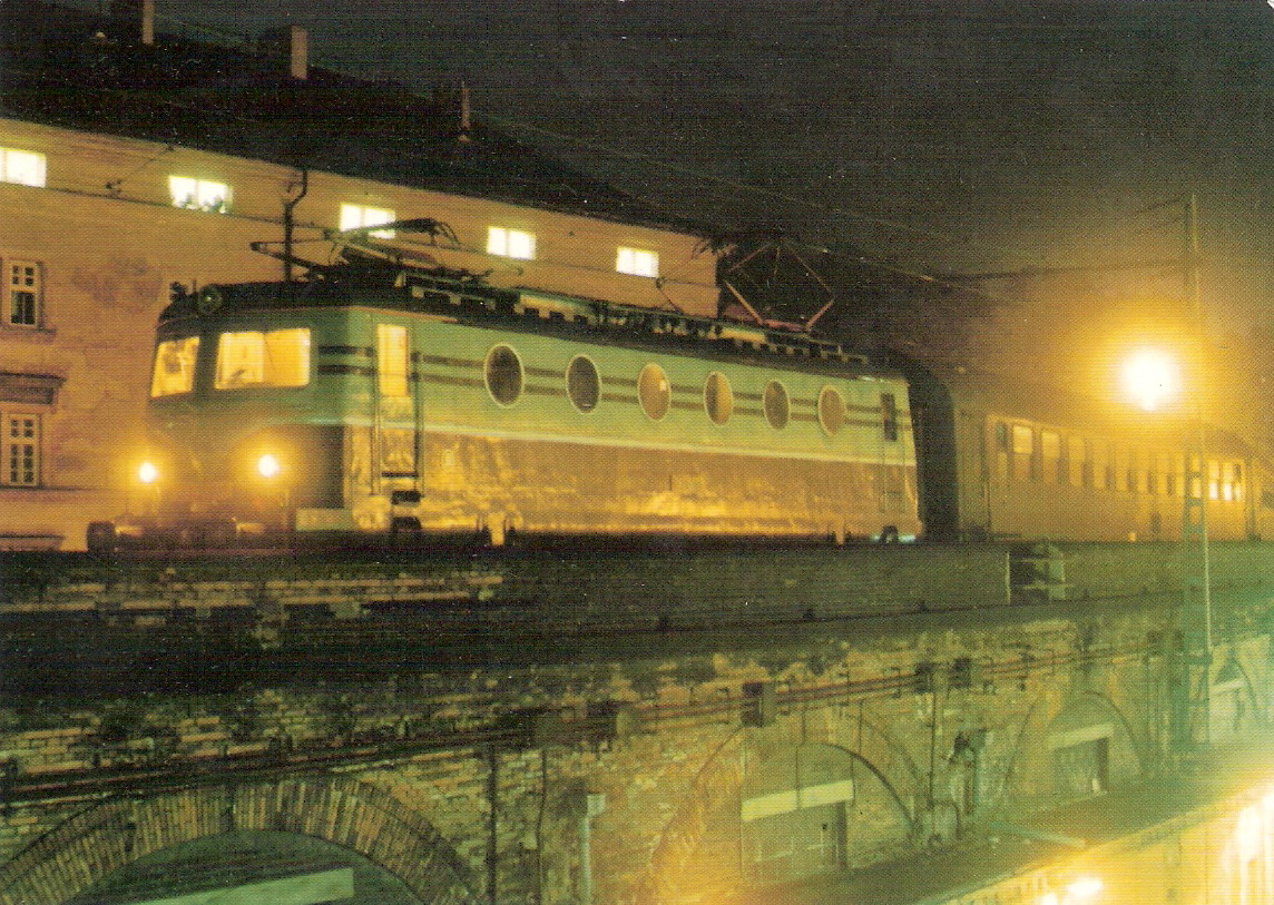  Elektrický rušeň 141 001-8 so súpravou vlaku os. prepravy na Negrelliho viadukte v Prahe. Nočný pohľad predobočný. Vzadu obytný dom. Foto: M. Šecl, 25.5.1993. 147 x 105, COLOR 