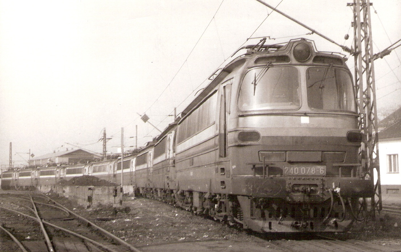  Elektrické rušne 240 078, 083, 098, 131, 016, 130, 080, 075 a 100 na drevenej koľaji starého depa Bratislava východ. Pohľad predobočný. Vpravo budova strojmajstrov, vľavo uhoľné skládky, vzadu nulová hala. Foto: P. Pytel, 20.2.1990. 178 x 120 