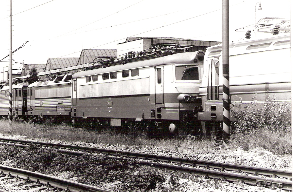 Elektrický rušeň S 499.0240 (242 240-0) medzi rušňami 240 a 363 v novom depe Bratislava východ. Pohľad predobočný. Vzadu diel. hala, vpredu trať koľaj z koľ. Sahara do Odb Vinohrady. Foto: D. Fedin, 6.7.1988. 147 x 106. 