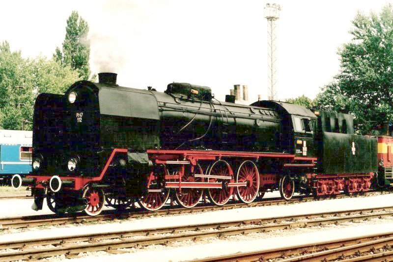  Parný rušeň Pt 47.112 PKP v starom depe Bratislava východ. Pohľad zľava zpredu. Vpravo časť vozňa WLAB PKP, vpravo časť rušňa 735. Vzadu osvetľ. maják. Foto: M. Entner, 8.1998. 178 x 126, COLOR 