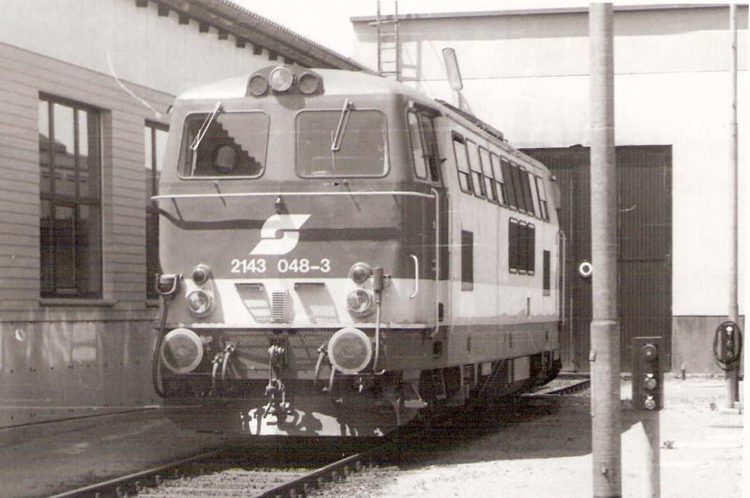  Motorový rušeň 2143 048-3 OeBB v depe Gmuend. Pohľad predobočný. Vzadu vráta remízy. Vľavo múr remízy. Foto: J. Česák, 30.6.1980. 136 x 92 