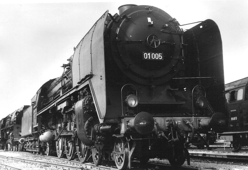  Parný rušeň 01 005 DR v depe Erfurt West. Pohľad zprava zpredu. Vzadu rušeň 01 517 DR, vpravo rušeň 95 6676 DR. Foto: Anon., 6.6.1982. 123 x 84 