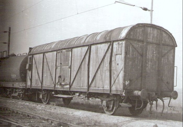  Nákladný dvojnápravový izotermický vozeň L v žst. Leopoldov. Pohľad predobočný. Vľavo cisterna Rah. Trolej, srdcovka výhybky. Foto: J. Kubáček, cca 1993. 111 x 111 