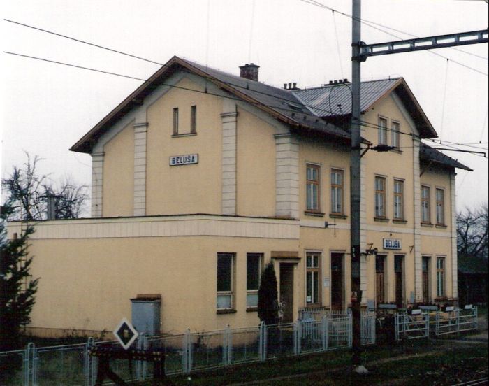  Beluša - výpravná budova. Šikmý pohľad zo strany koľají od Žiliny. Trolej, osvetľ. stožiar. Foto: M. Entner, 14.12.1996. 126 x 89, COLOR 