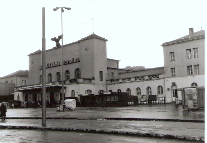  Bratislava hl. st. - výpravná budova. Šikmý pohľad z predstaničného priestoru od Rače. Stánky, odpadkový kontajner. Foto: Anon., cca 1983. 115 x 80 