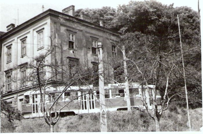  Bratislava, prvá parostrojná stanica - výpravná budova. Šikmý pohľad na račianske krídlo budovy z predstaničného priestoru od Rače. Pred budovou električka T3. Foto: Anon., 8.10.1976. 140 x 92 