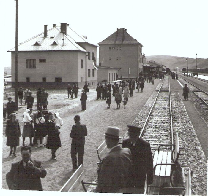  Brezno (Brezno nad Hronom) - nová stanica. Výpravná budova a priľahlé objekty. Pohľad v osi koľaje smerom na Č. Skalu. Ľudia, vpredu drezína s lavičkami. Foto: Anon., cca 1943. 99 x 96 