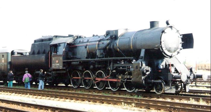  Parný rušeň 52 4984 OeBB s rýchlikom OeBB v žst. Bratislava východ. Pohľad zprava zpredu. Vľavo rušeň 240 ŽSR. Vpravo osvetľ. maják a vozne na prekládke. Foto: M. Entner, 8.1998. 178 x 126, COLOR 