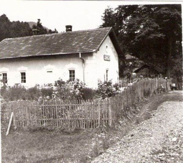  Hvozdnica (pri Voznici) - výpravná budova. Šikmý pohľad zo strany koľají od Levíc. Oplotená záhradka. Foto: Anon., cca 1945. 96 x 98 