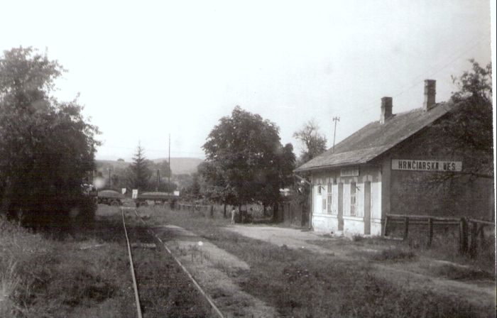  Hrnčiarska Ves - výpravná budova. Šikmý pohľad zo strany koľají od Rimavskej Soboty. Vzadu prechádza nákladné auto s vlečkou cez priecestie. Foto: J. Kubáček, 30.7.1992. 178 x 125 