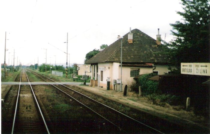  Kostolná-Záriečie - výpravná budova. Šikmý pohľad od Žiliny. Dvojkoľajná elektrifikovaná trať, priecestie AŽD. Foto: M. Entner, 17.8.1996. 126 x 89, COLOR 