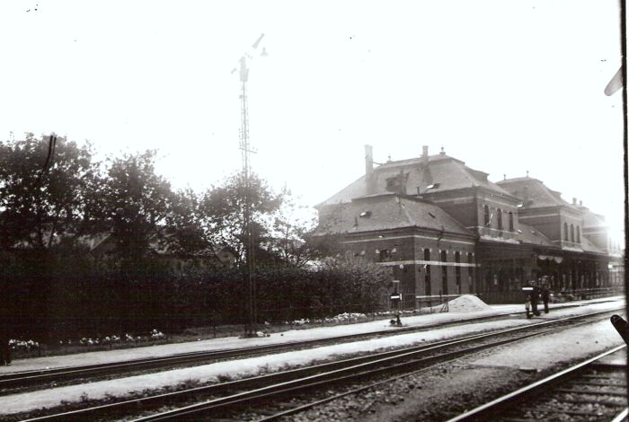  Leopoldov - výpravná budova nová. Šikmý pohľad zo strany koľají od Žiliny. Výhybky s kruhovým lampami, konzolový osvetľovací stožiar. Foto: Anon., cca 1930. 177 x 127 