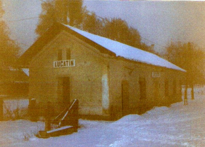  Lučatín - výpravná budova. Zimný večerný šikmý pohľad zo strany koľají od Zvolena. Foto: Anon., cca 1995. 126 x 89, COLOR 