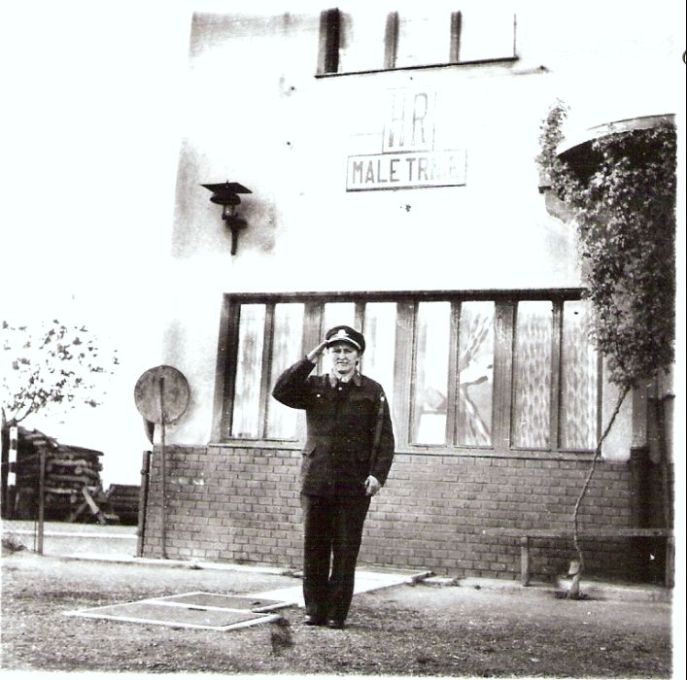  Malé Trnie - výpravná budova. Čelný pohľad na bratislavskú časť priečelia. Malé zvonkové návestidlo, salutujúci hradlár. Foto: Anon., cca 1950. 96 x 93 