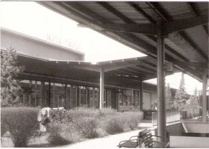  Nové Zámky - výpravná budova nová. Šikmý pohľad zo strany koľají na centrálnu časť budovy. Vpravo prestrešenie 1. perónu. Foto: J. Kubáček, jar 1993. 126 x 88 