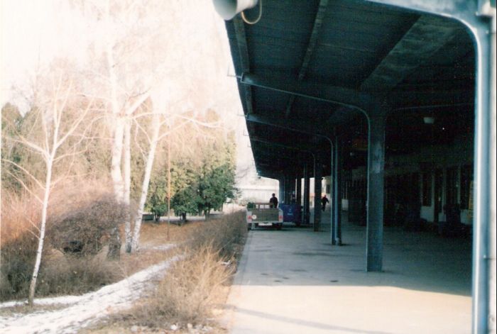  Partizánske - výpravná budova. Pozdĺžny pohľad v osi koľaje popod prestrešenie na priečelí výpravnej budovy od Topolčian. Foto: M. Entner, 3.1996. 126 x 89, COLOR 