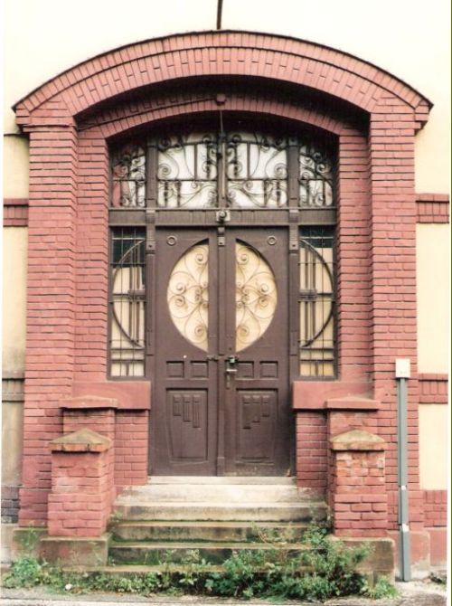  Vrútky - budova konzumu. Čelný pohľad zo strany koľají na vstupné dvere. Foto: M. Entner, 13.9.1996. 126 x 178, COLOR 