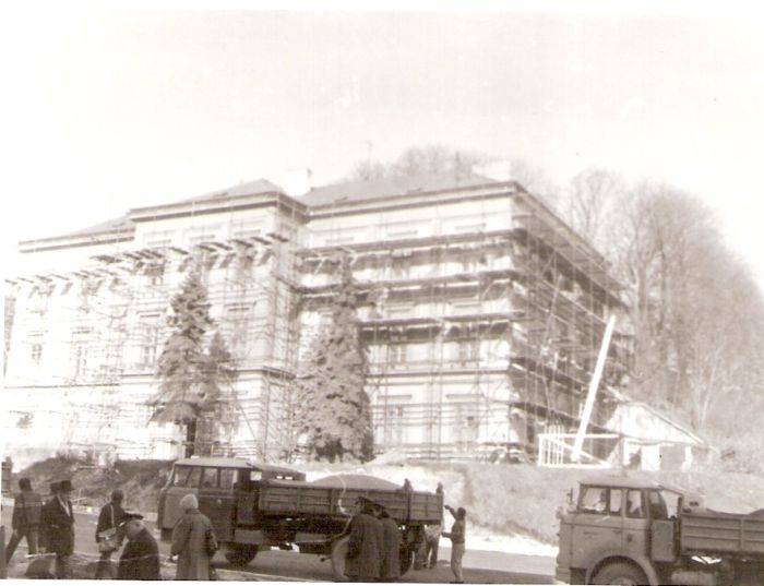  Bratislava, prvá parostrojná stanica - výpravná budova. Šikmý pohľad z predstaničného priestoru od Rače. Budova pod lešením. Vpredu nákladné autá. Foto: Anon., cca 1980. 124 x 84 