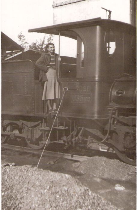  Úzkorozch. parný rušeň U 35.103. Pohľad na kabínu rušňa, predok tendra a 3. nápravu zprava. Na stanovišti rušňovodiča žena v civile. Vzadu múr budovy, o kabínu opreté ohreblo. Foto: Ing. Héger, 1949. 80 x 129 