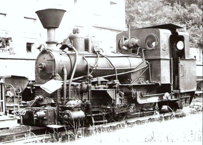  Úzkorozch. parný rušeň č. 3 priemyselnej dráhy v Mladějove, zrejme v stanici Hřebeč. Pohľad zľava zpredu. Vzadu admin. Budova a plech. huntíky. Foto: J. Kubáček, cca 1975. 127 x 88 