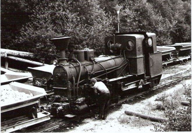  Úzkorozch. parný rušeň č. 3 priem. dráhy v Mladějove so súpravou plech. huntíkov pri križovaní s druhým vlakom huntíkov. Pohľad zľava zpredu. Rušňovodič pri ošetrení rušňa. Foto: J. Kubáček, cca 1975. 127 x 90 