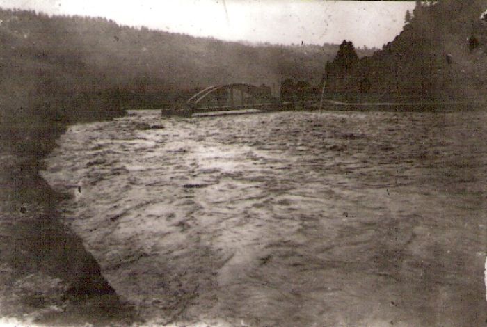  Rozvodnená rieka, v nej cestný betónový krajinský most. Foto: Anon., cca 1960. 88 x 60 